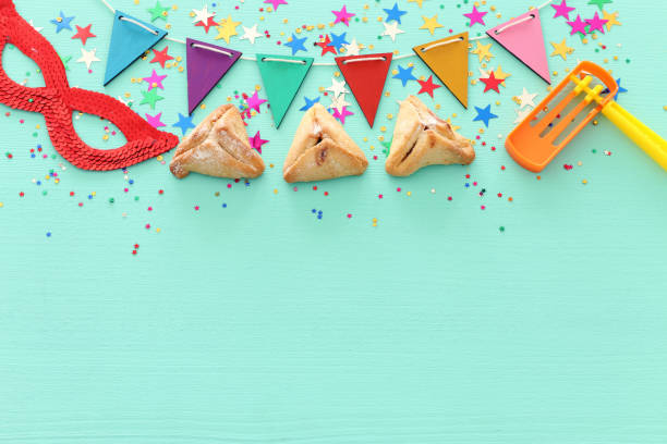 Purim celebration concept (jewish carnival holiday) over wooden mint background.