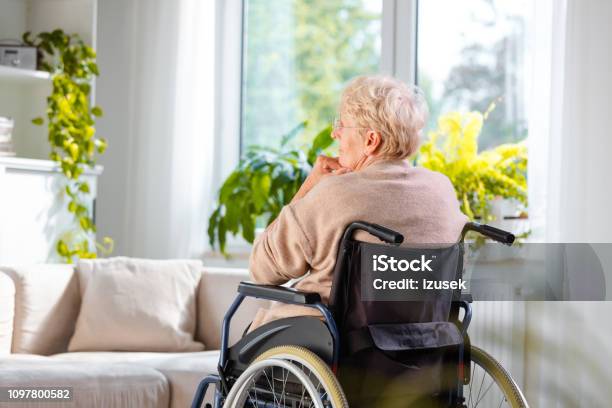 Lonely Senior Woman Sitting In Wheelchair In Her House Stock Photo - Download Image Now
