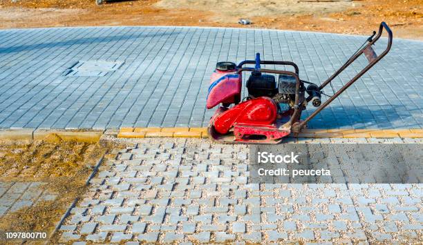 Vibrator With Rubber Plate For Compacting Paving With Interlocking Blocks Stock Photo - Download Image Now