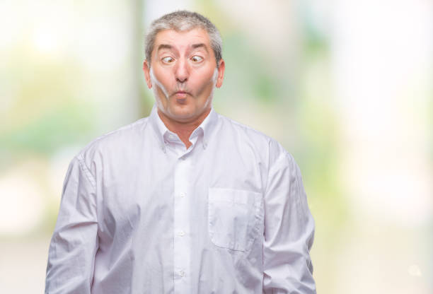 istock Handsome senior man over isolated background making fish face with lips, crazy and comical gesture. Funny expression. 1097800878