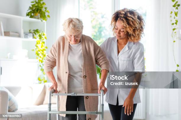 Nurse Helping An Elderly Lady In Using Mobility Walker Stock Photo - Download Image Now