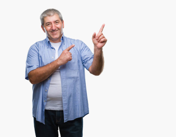 istock Handsome senior man over isolated background smiling and looking at the camera pointing with two hands and fingers to the side. 1097802390