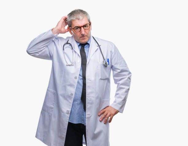 istock Handsome senior doctor man over isolated background confuse and wonder about question. Uncertain with doubt, thinking with hand on head. Pensive concept. 1097802474