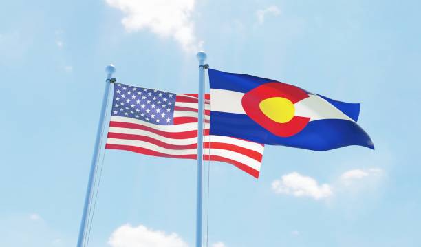 usa and state colorado, two flags waving against blue sky - colorado flag imagens e fotografias de stock