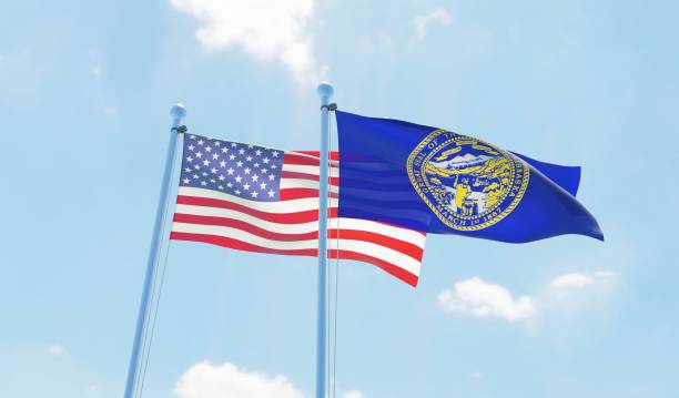 istock USA and state Nebraska, two flags waving against blue sky 1097803862