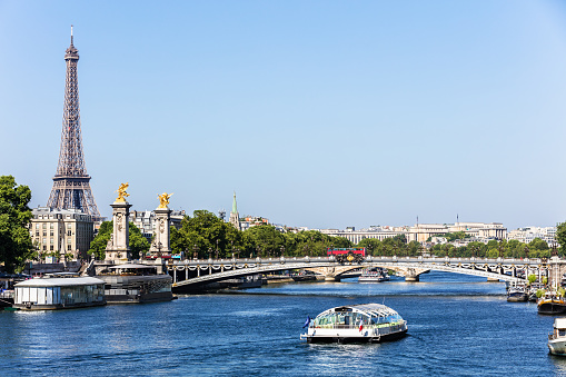 Panorama of the Pont Alexandre III bridge over the River Seine and the Eiffel Tower in the summer morning. Bridge decorated with ornate Art Nouveau lamps and sculptures. Paris, France.