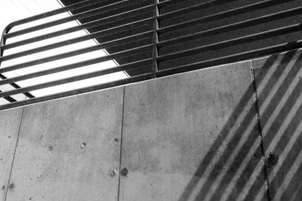 istock Railing, concrete wall and shadows make geometric designs in the light - Low Angle - Black and White 1097811610