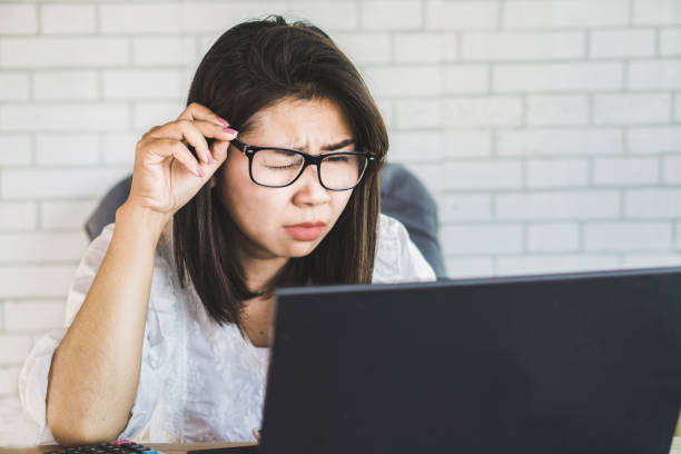 istock Asian woman worker with eye vision  problem try to watch on computer screen 1097817066