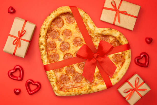 istock Pizza shaped heart with red bow ribbon and present box for Valentine's Day romantic concept on red background 1097817142
