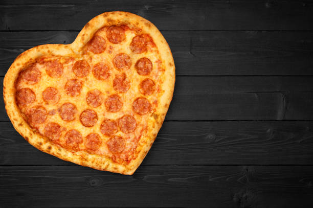 istock Pizza heart for Valentine's Day romantic concept copy space on rustic dark black background. Top View. Flat lay 1097817868