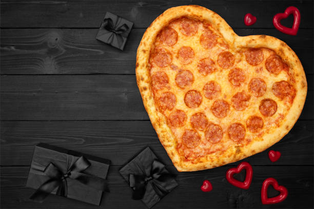 istock Pizza shaped heart with gift box for Valentine's Day romantic concept copy space on rustic dark black background. Top View. Flat lay 1097818936