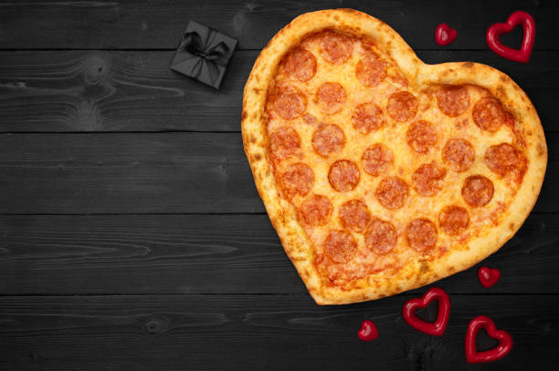 istock Pizza heart for Valentine's Day with copy space on rustic dark black background. Top View. Flat lay 1097818982