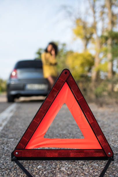 istock Woman with broken car and triangle 1097820114