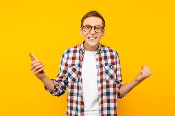 istock successful man with a phone, on a yellow background 1097822448