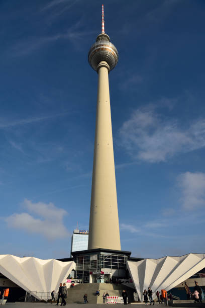 Soaring shaft and silver sphere of Fernsehturm TV tower in Berlin Berlin, Germany - November 10, 2018. Soaring shaft and silver sphere of Fernsehturm TV tower in Berlin, with Body Worlds (Menschen Museum) and people. plastination photos stock pictures, royalty-free photos & images