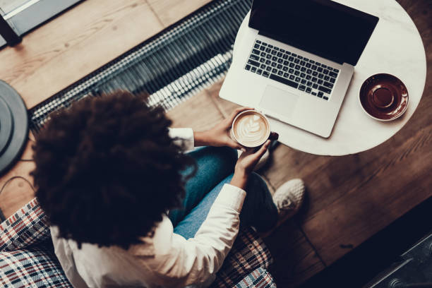 istock Lady with cup of cappuccino looking at laptop display 1097823292