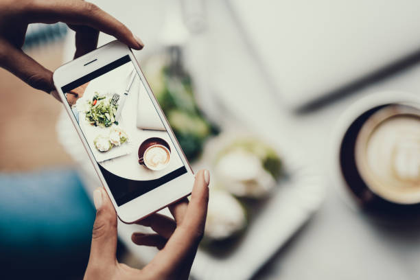 mujer con celular en las manos y toma foto de su comida - alimento fotos fotografías e imágenes de stock