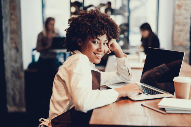 istock Smiling woman sitting inside cafe and using laptop 1097823480
