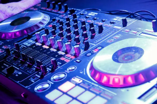 Photo of DJ control gear, electronic night party