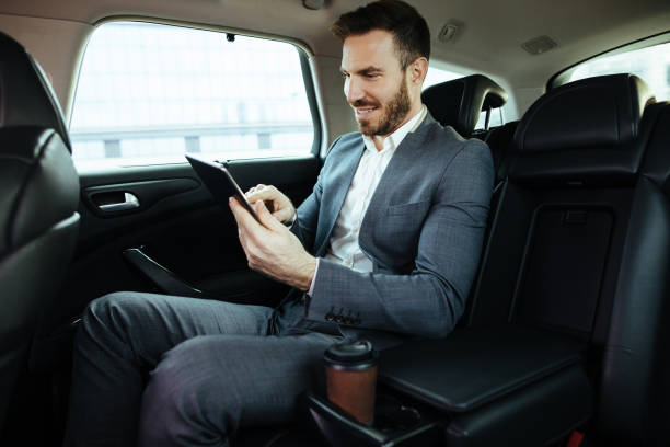 istock Businessman in a car holding digital tablet and smiling 1097833868