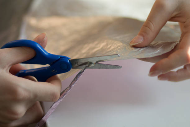 istock woman hands cutting paper material with scissors 1097840024