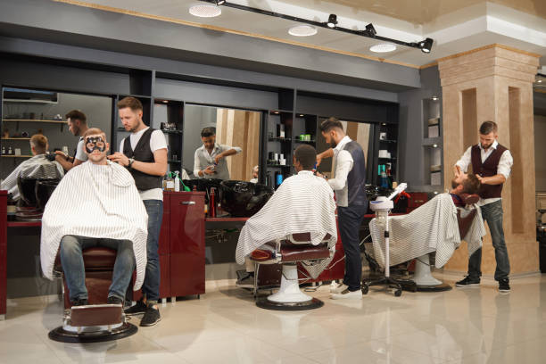 istock View from back of barbers servicing clients in barber shop 1097840326