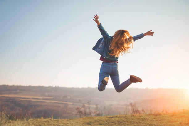 saut heureux par la fille dans la nature - joie photos et images de collection