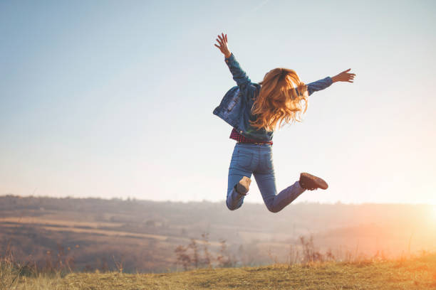 自然の女の子が幸せジャンプ - jump for joy ストックフォトと画像