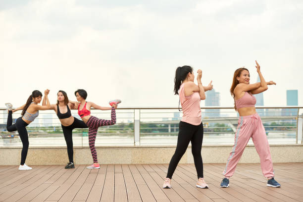 istock Group of women doing yoga on seafront 1097844536