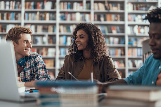istock Friendly students smiling to each other while sitting at the table 1097847456