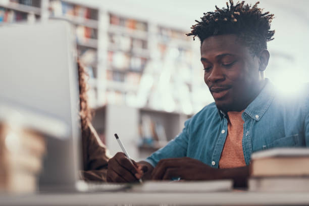 istock Calm Afro-American young man making notes and smiling 1097847524