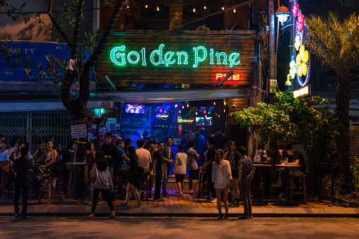 Danang, Vietnam - October 14, 2018: the exterior of Golden Pine Pub and its night visitors. This is one of the notable nightlife spots of the Da Nang City.