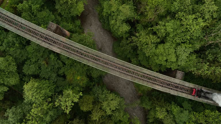 Aerial of old steam train on a trestle from above looking down