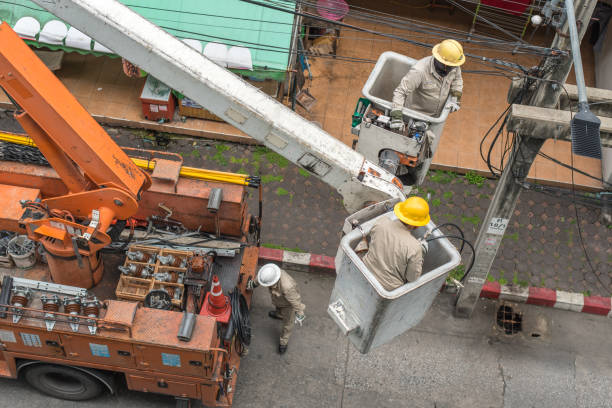 electricians repair an electric pole in bangkok - editorial land vehicle construction equipment built structure imagens e fotografias de stock