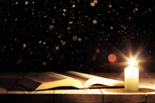 istock a bible on the table in the light of a candle 1097854680