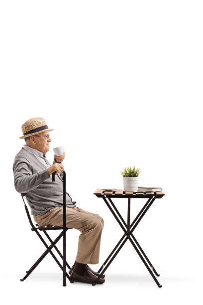 istock Senior man with cane sitting and drinking coffee 1097863782