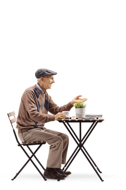 istock Senior man sitting at a coffee table and gesturing a conversation 1097863822
