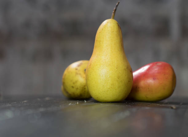 istock Group of ripe pears on dark rustic wooden table. Side view horizontal shot. Empty copyspace for your design. 1097872268