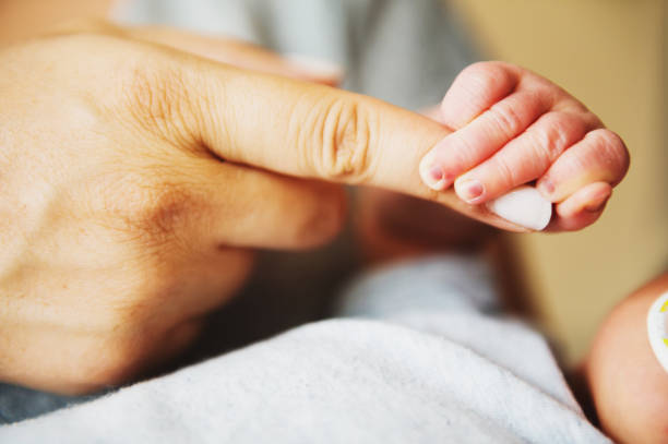 istock Newborn baby holding parents finger 1097883006