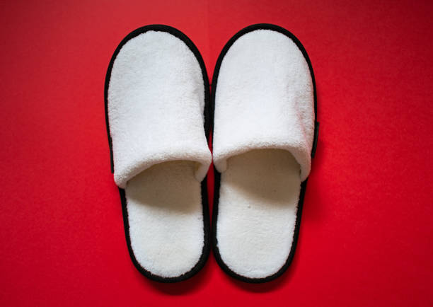 Selfie slippers on concrete background, Top view. Beautiful young woman wearing white slipper and pants. Clear warm domestic sandal. Soft comfortable bed shoes accessory footwear.
