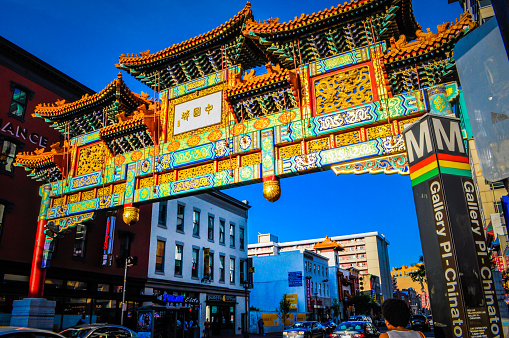 Pedestrians walk near the traditional gate in Chinatown, Los Angeles, California, USA on a sunny day.