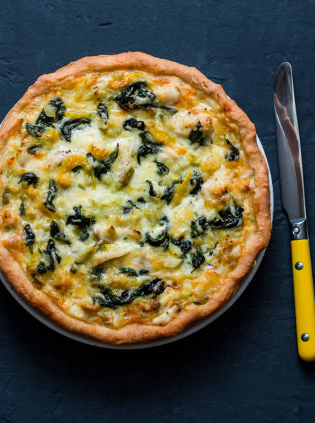 istock Chicken, leek, cheese, spinach quiche on dark background, top view 1097903560