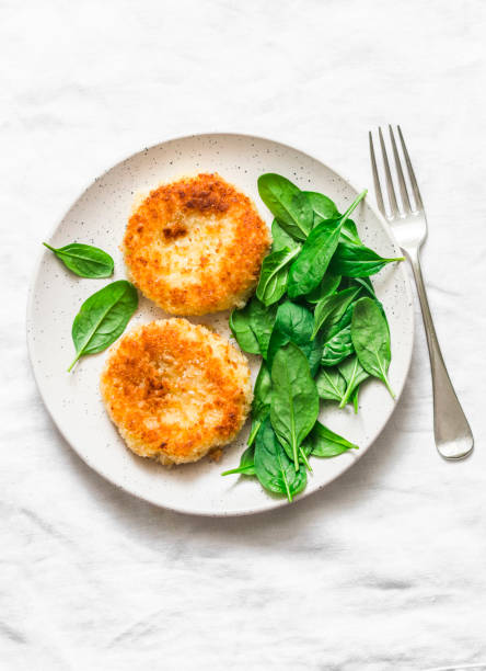 istock Potato bread crumbs baked cakes with spinach on a light background, top view. Delicious vegetarian lunch 1097903608