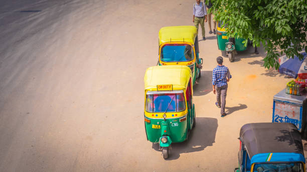 amarillo auto rickshaws en nueva delhi, india en el camino - editorial crowd driver people fotografías e imágenes de stock