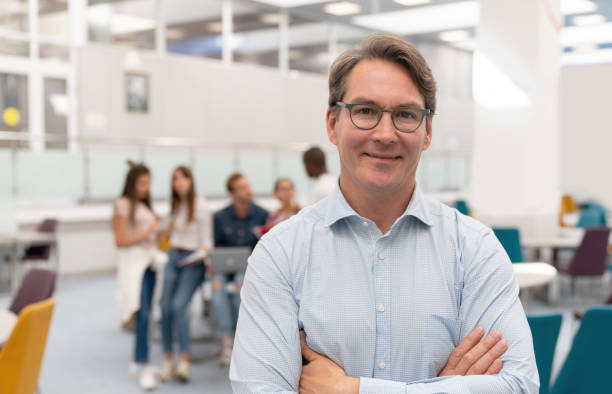 istock Happy teacher in a classroom looking at the camera and smiling 1097904288