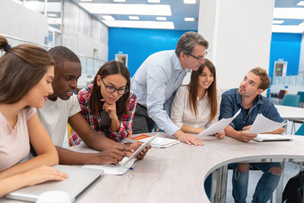 istock Happy group of students in a classroom with their teacher 1097904370