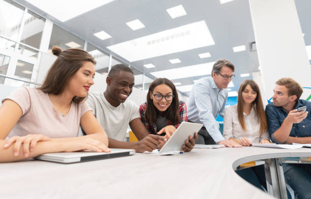 istock Happy group of students in a classroom with their teacher 1097904480