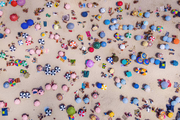 widok z góry kolorowych parasoli i ludzi relaksujących się na plaży w słoneczny dzień, copacabana, rio de janeiro, brazylia - rio de janeiro copacabana beach ipanema beach brazil zdjęcia i obrazy z banku zdjęć