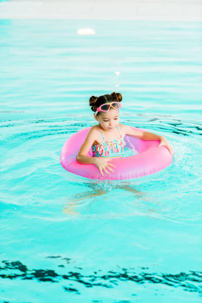 istock happy kid swimming with inflatable ring in swimming pool 1097906120