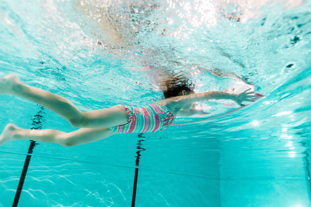 istock kid swimming in blue water in swimming pool 1097906122